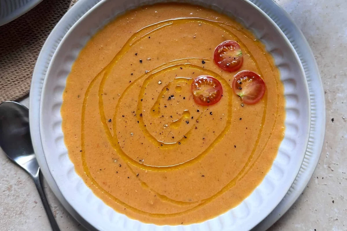 Belizean Beef and Bean Soup Recipe: A Traditional Caribbean Comfort Dish 2 A bowl of creamy, vibrant orange butternut squash and tomato soup garnished with fresh herbs.