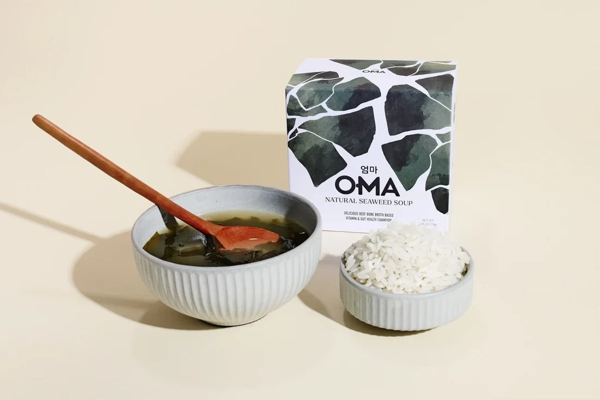 A steaming bowl of traditional Belizean Oma seaweed soup garnished with fresh cilantro and scallions.