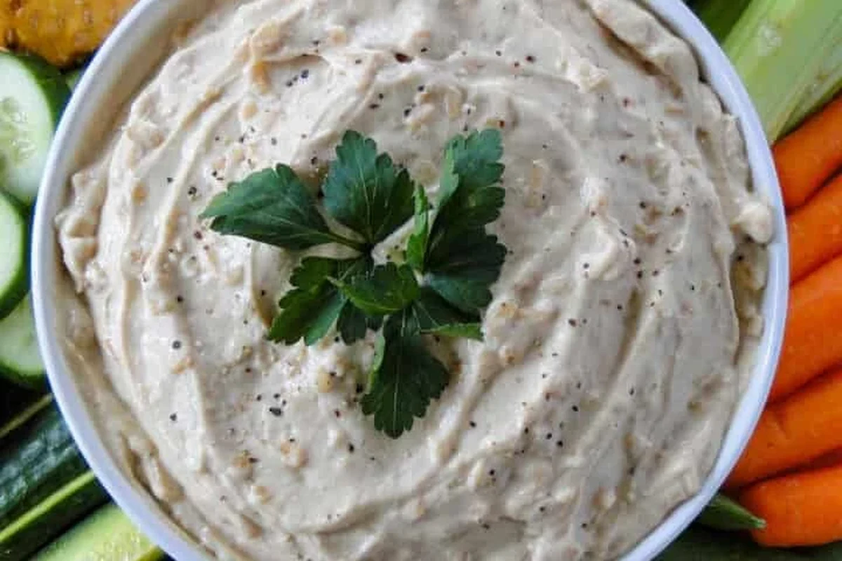 Onion Dip with Onion Soup Mix: Easy Creamy Party Recipe 1 A bowl of creamy onion dip served with potato chips on a wooden table.