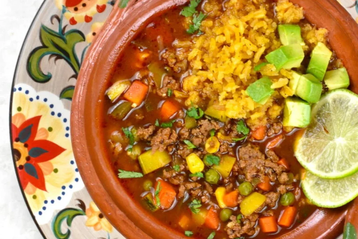 Picadillo Soup Recipe: A Hearty Belizean Comfort Food Guide 2 A steaming bowl of Belizean picadillo soup with ground meat, diced carrots, potatoes, and fresh cilantro.