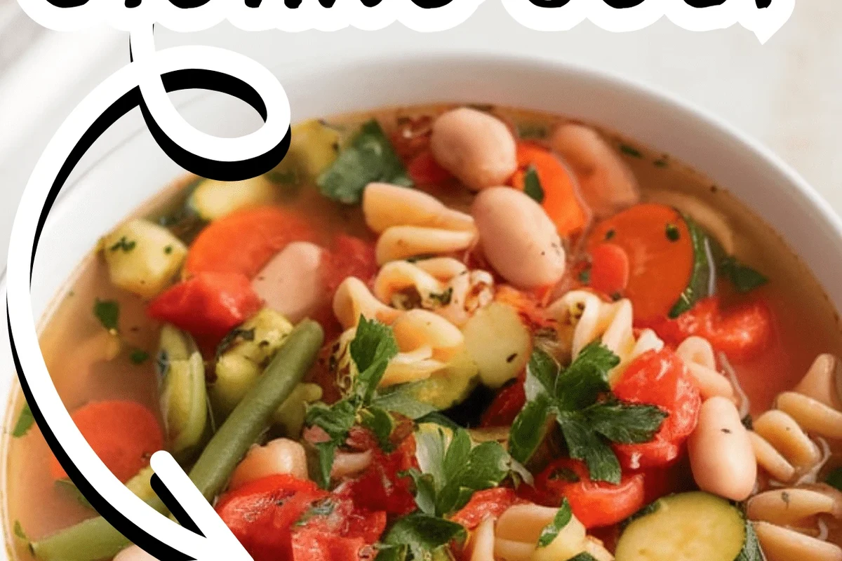 A steaming bowl of rustic Zuppa Del Giorno soup with fresh herbs in a home kitchen setting.