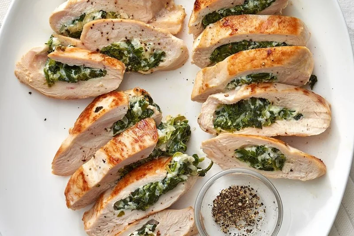 A perfectly pan-seared 12 oz chicken breast with herbs on a wooden cutting board.