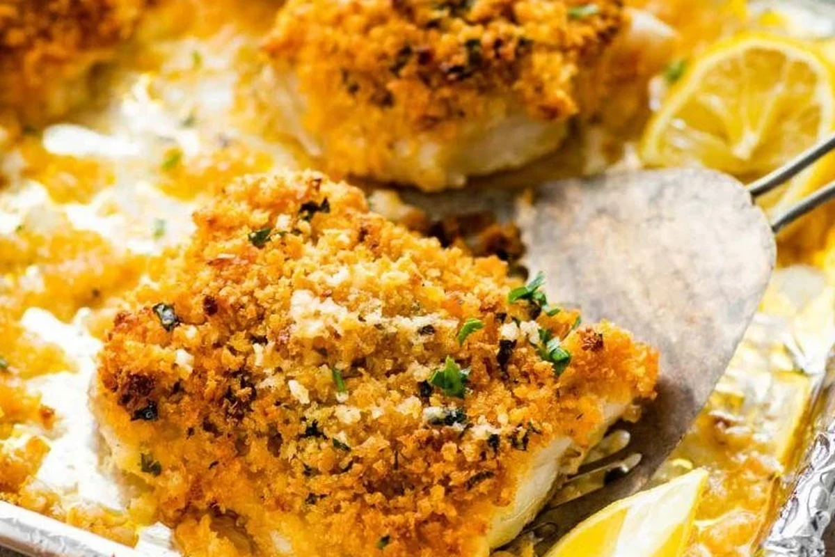 A perfectly baked fillet of black cod with a citrus glaze and fresh herbs on a plate.