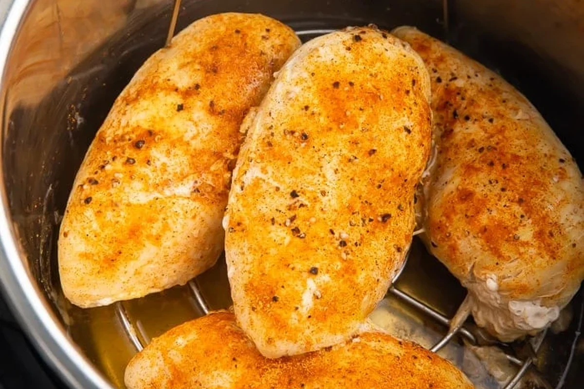 Frozen Chicken Breast in Instant Pot 2 A stainless steel Instant Pot containing cooked, tender chicken breasts on a metal trivet.