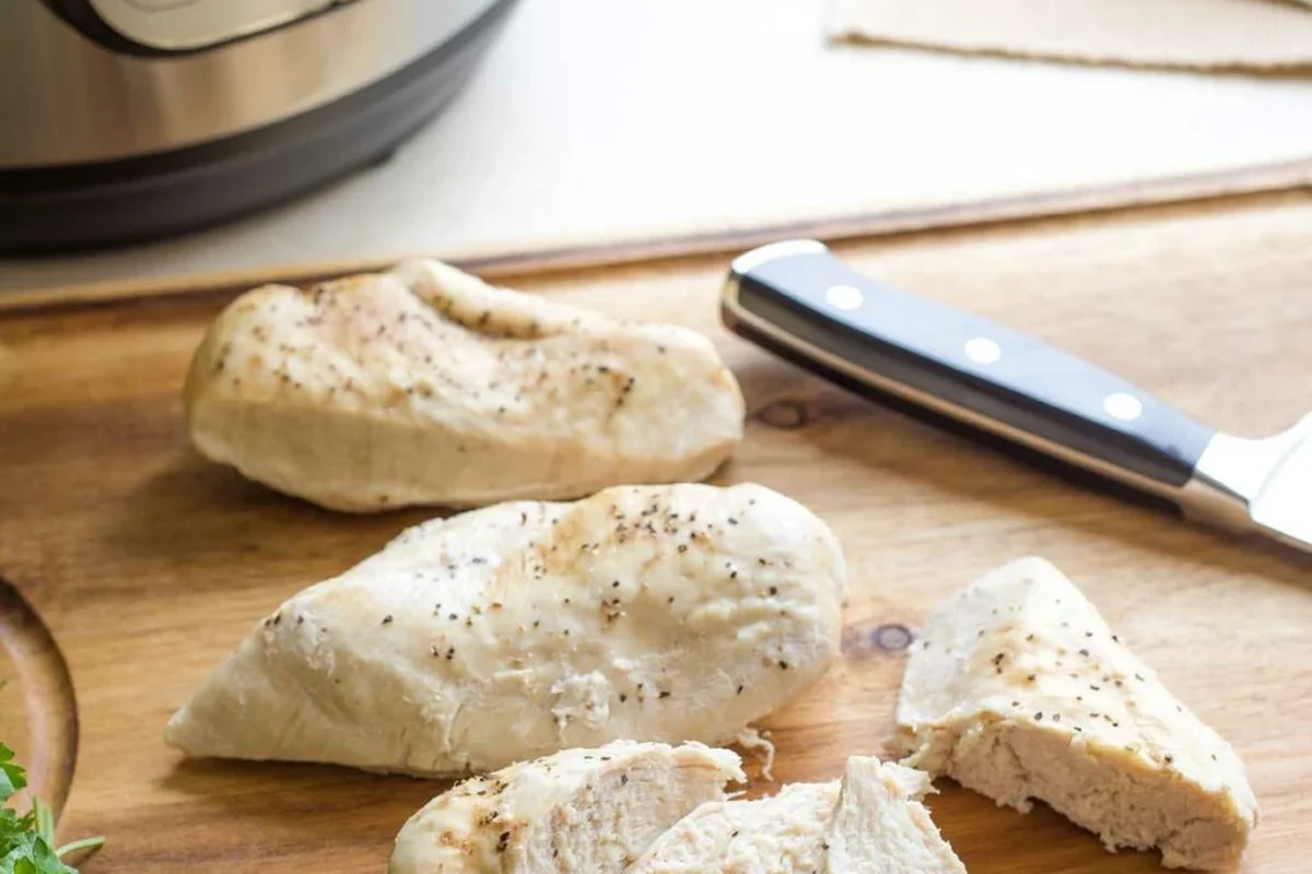 Frozen Chicken in Instant Pot 1 A cooked piece of chicken in an Instant Pot with aromatic spices and broth.