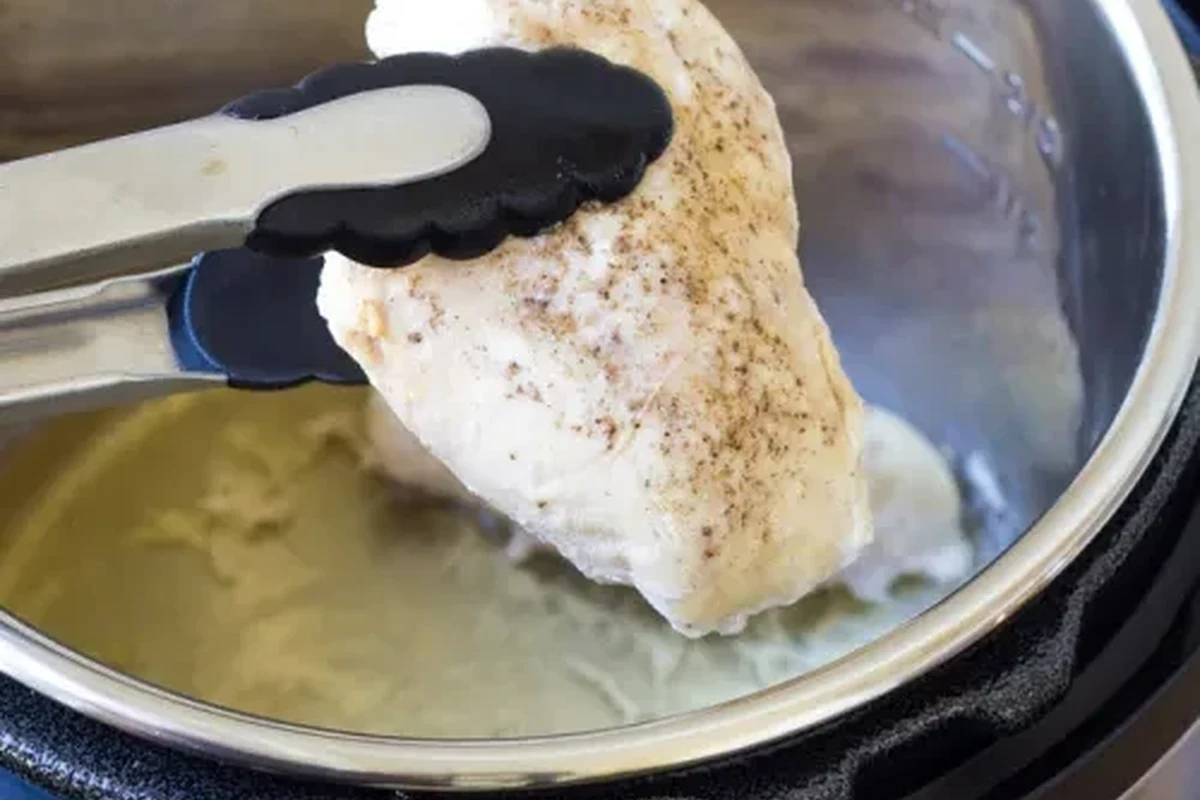 Frozen Chicken in Instant Pot 2 A cooked piece of chicken in an Instant Pot with aromatic spices and broth.