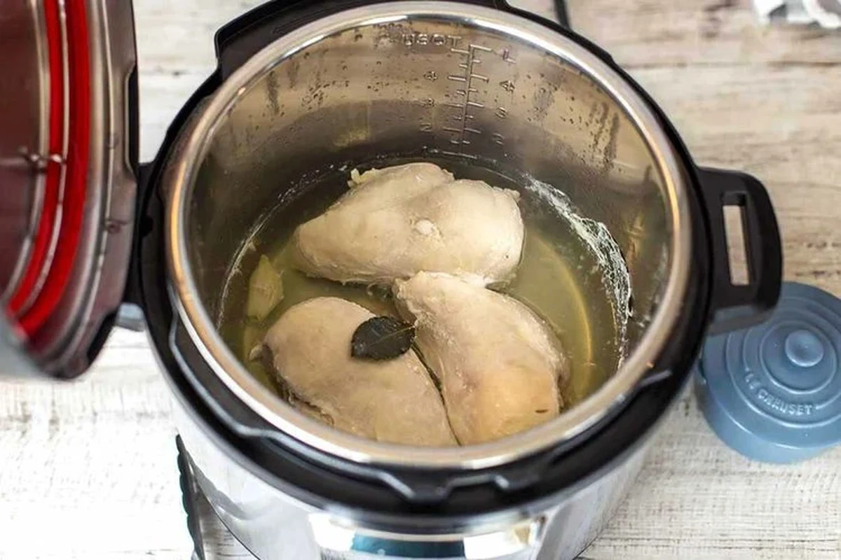 A cooked chicken breast inside an Instant Pot, showing tender, juicy meat ready for shredding.