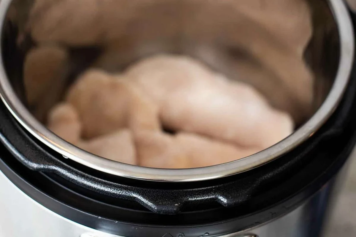 A cooked chicken breast inside an Instant Pot, showing tender, juicy meat ready for shredding.