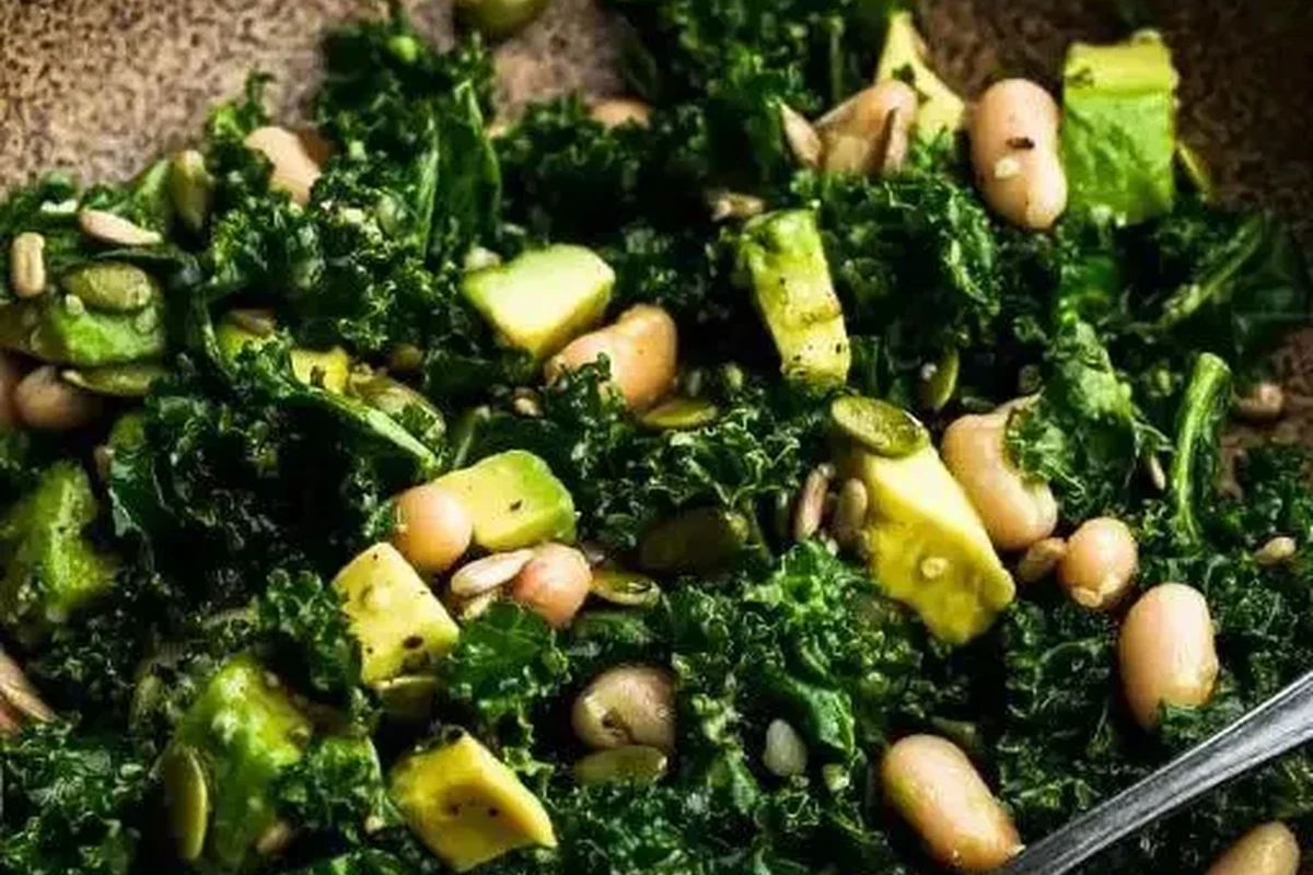 A fresh bowl of massaged kale and creamy cannellini beans tossed in a light vinaigrette with shaved parmesan.