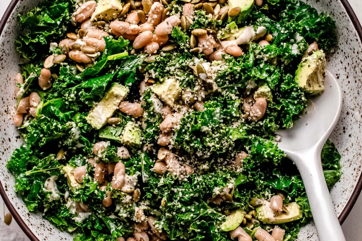 Kale and White Bean Salad 1 A fresh bowl of massaged kale and white beans with a light vinaigrette and colorful vegetable accents.