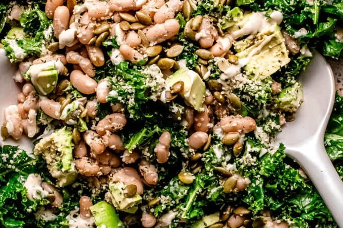 A bowl of fresh Lacinato kale and white bean salad with a lime vinaigrette dressing.