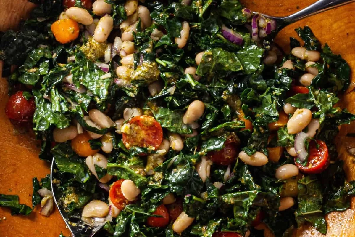 Kale and White Bean Salad 2 A fresh bowl of massaged kale and white beans with a light vinaigrette and colorful vegetable accents.