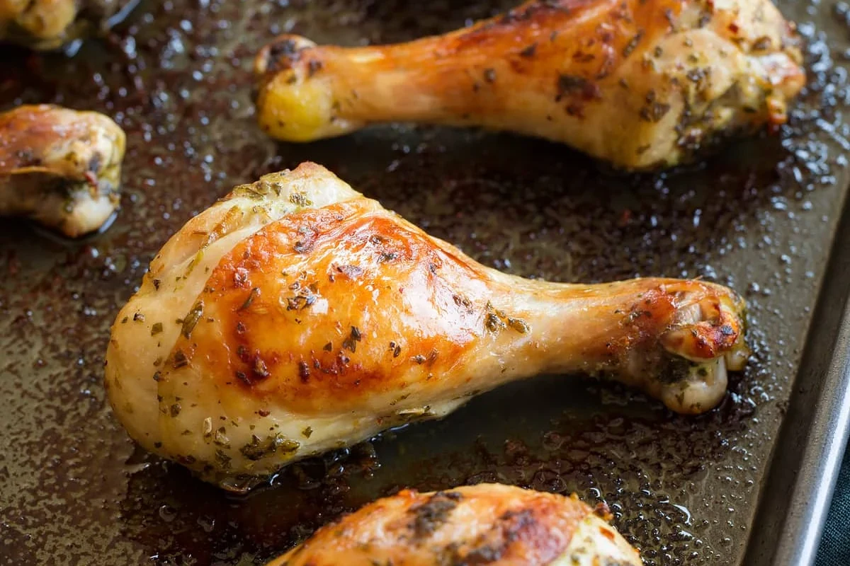 Crispy oven-baked chicken drumsticks on a wire rack with seasoning.