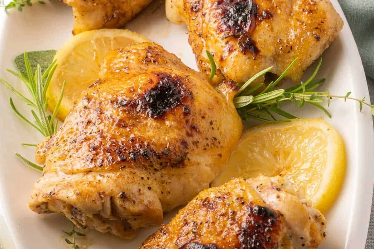 Golden brown seasoned chicken breasts cooking on a broiler pan in an oven