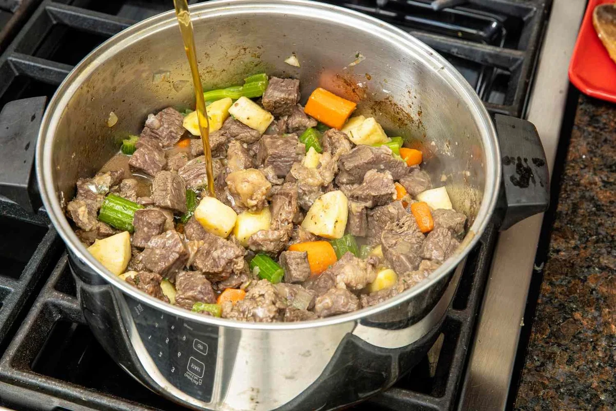 How Long to Cook Stew Meat on Stove 2 A hearty beef stew simmering in a heavy-bottomed pot on a stovetop with visible chunks of tender meat and vegetables.