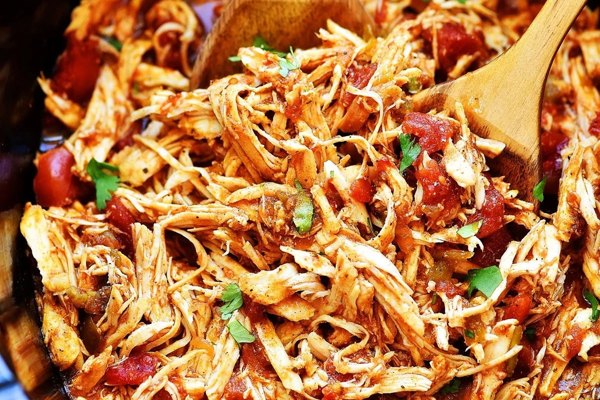 A bowl of perfectly cooked and shredded chicken ready for meal preparation.