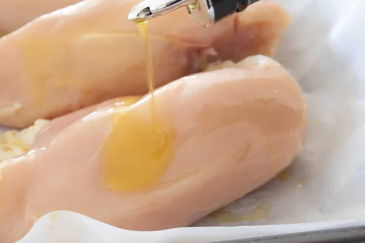 A golden-brown pan-seared chicken breast seasoned with herbs and finished with a drizzle of olive oil.