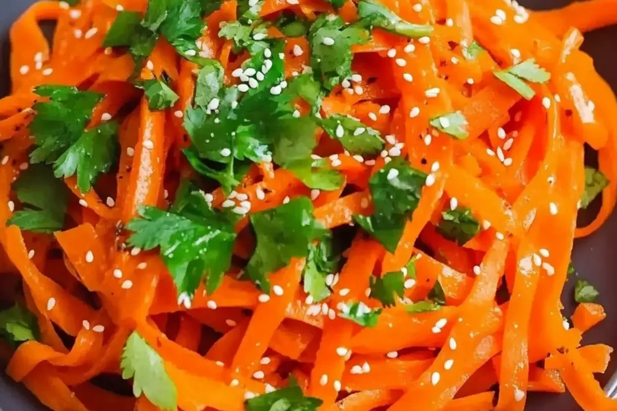 Raw Carrot Salad Recipe 2 A vibrant bowl of freshly grated raw carrot salad with lime and herbs.