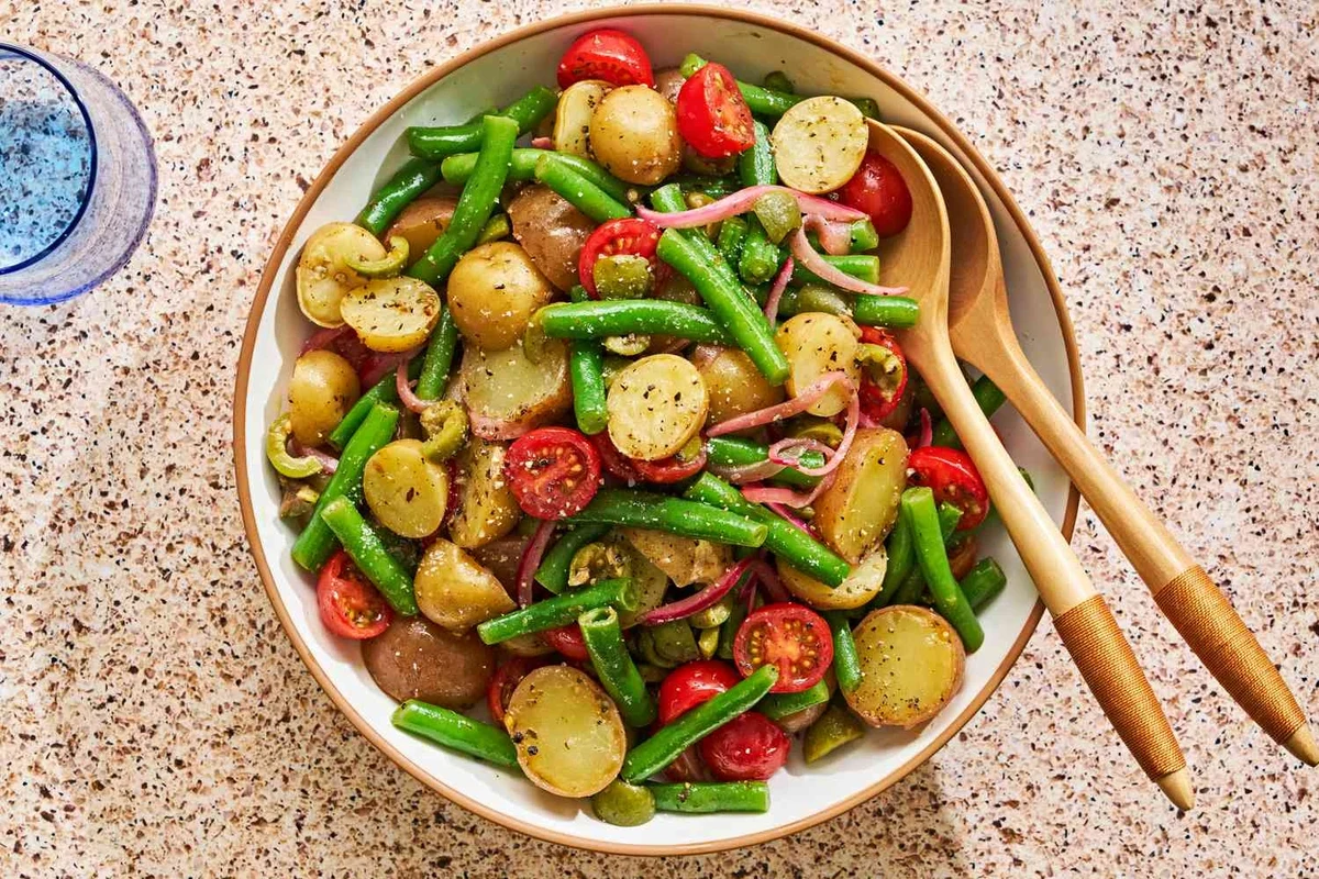 A rustic bowl of Sicilian potato salad with fresh parsley, olives, and a light olive oil dressing.