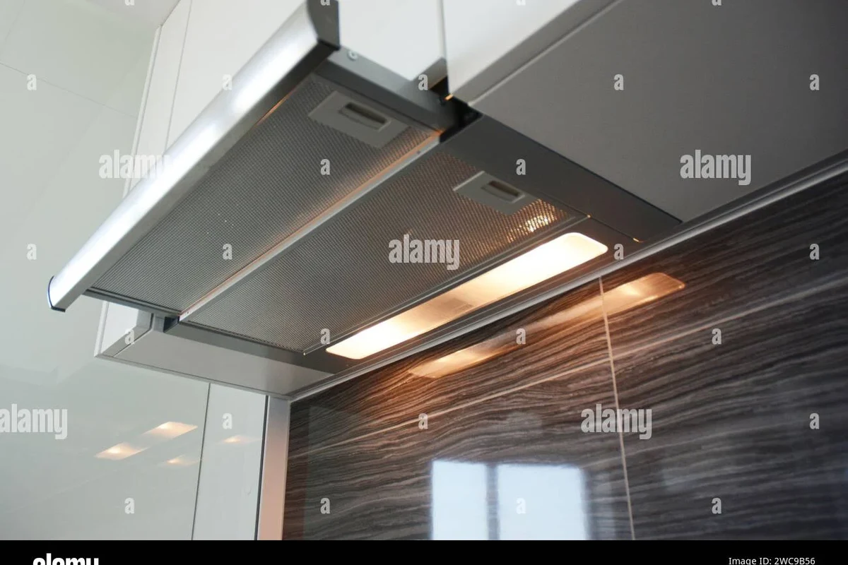 A modern, custom-built vent hood cabinet finished in white to match kitchen cabinetry.