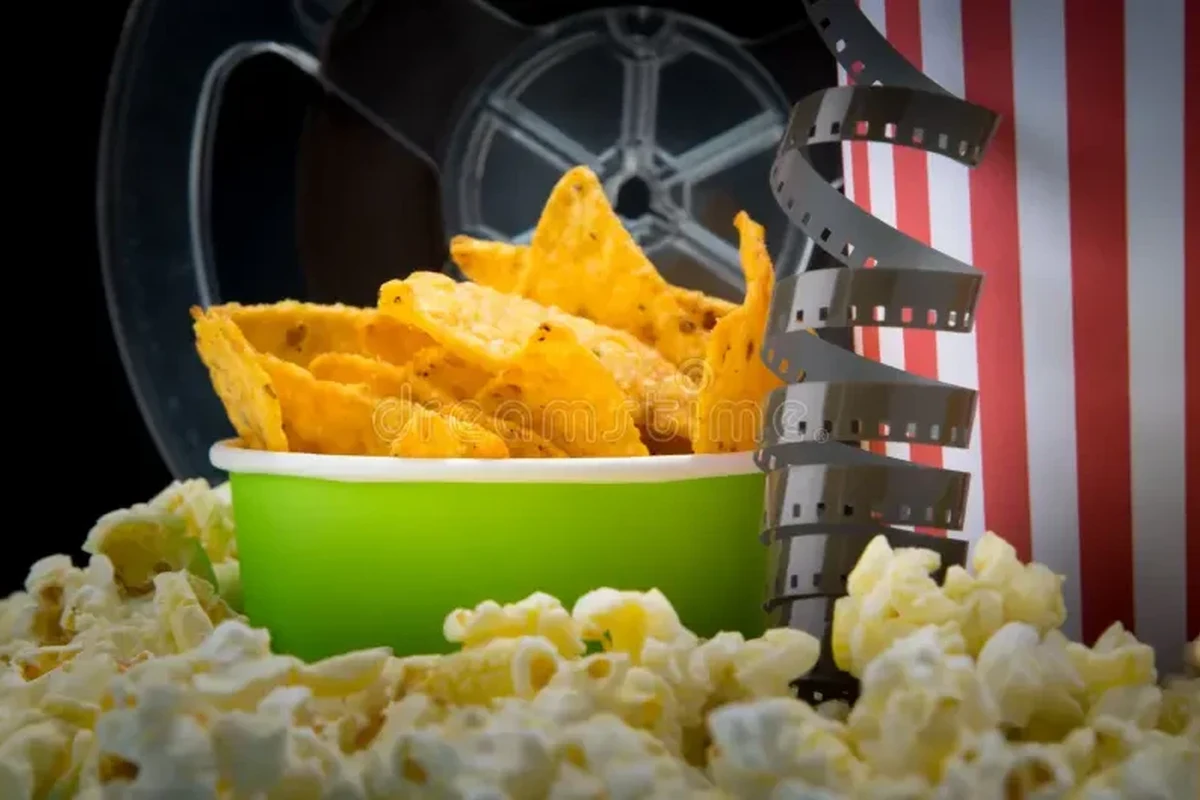 Movie night snack spread with popcorn, plantain chips, and Belizean bite-size treats